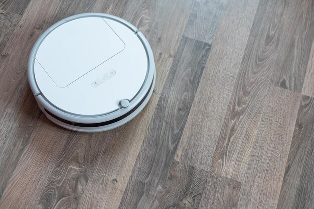 Varios robots aspiradores de diferentes marcas sobre un suelo de madera.